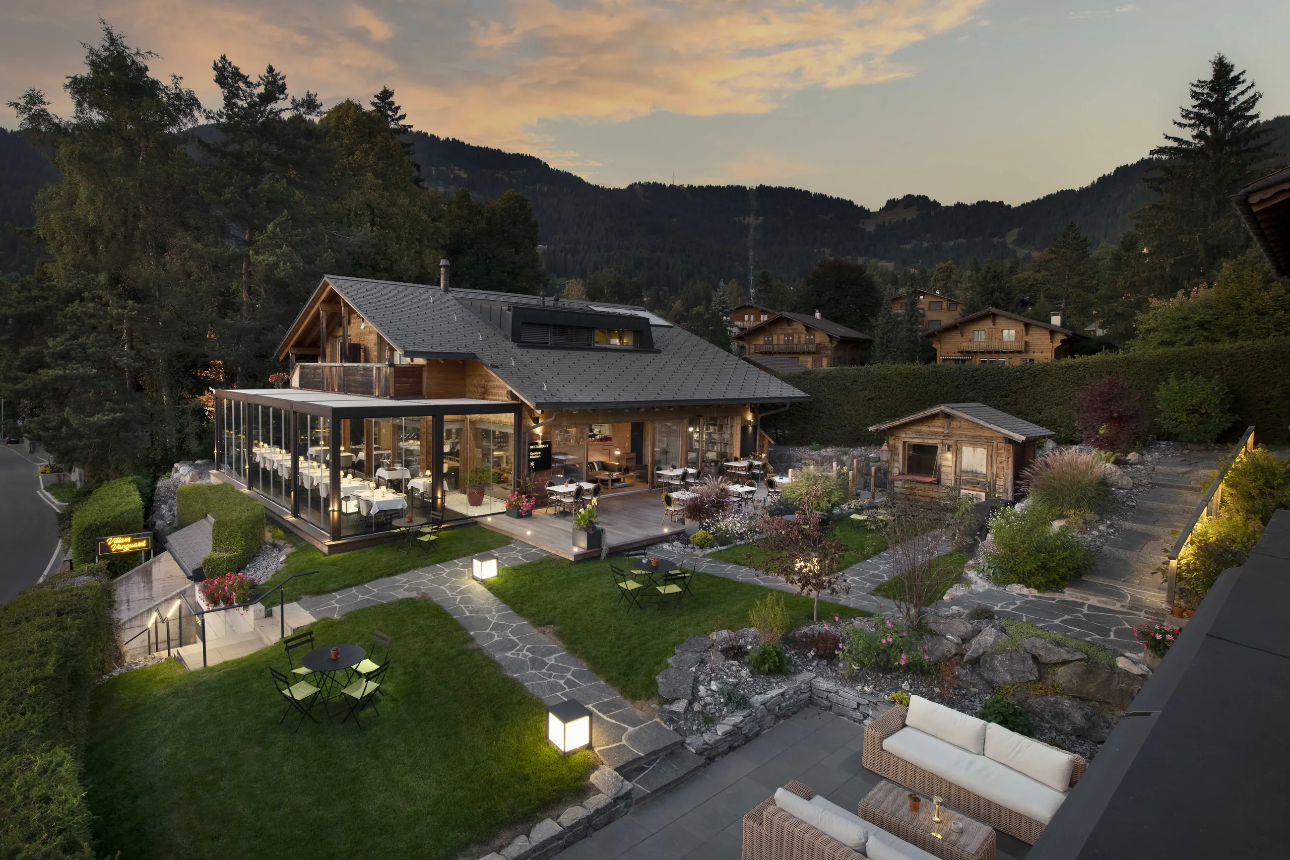 Les Mazots du Clos at dusk, the glass dining room and the garden
