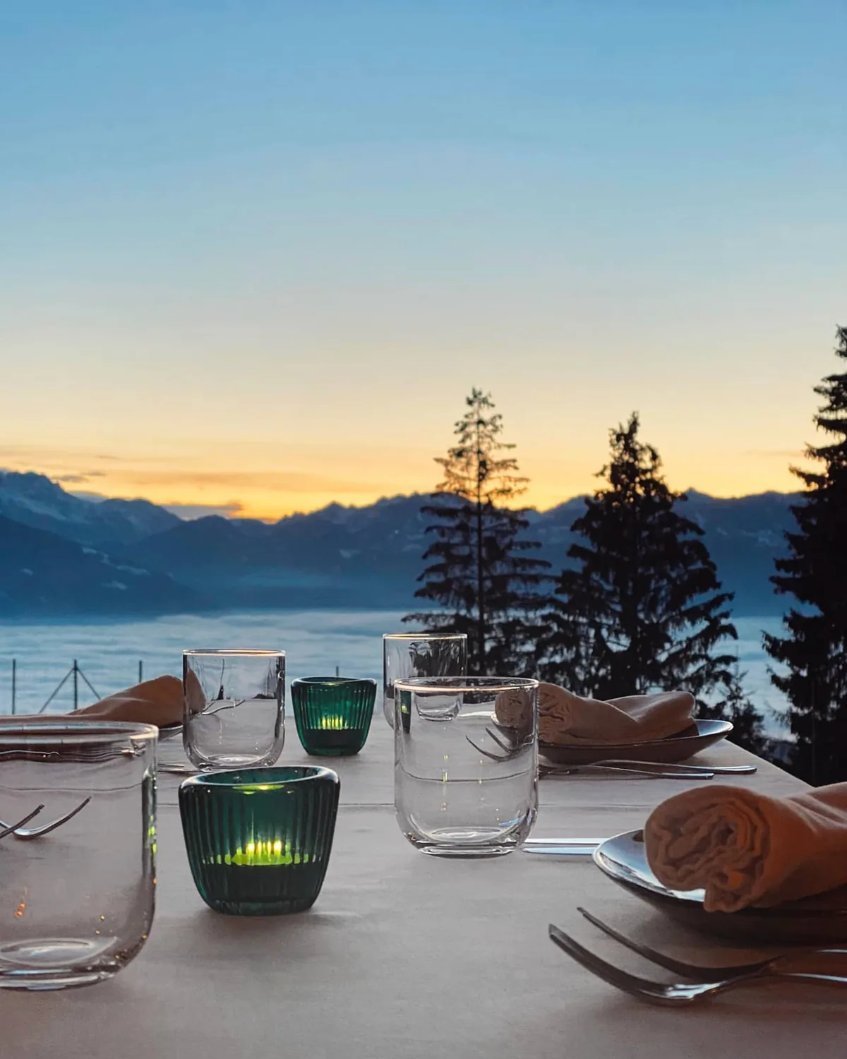 A table laid above the sea of cloud, the peaks catching the last light