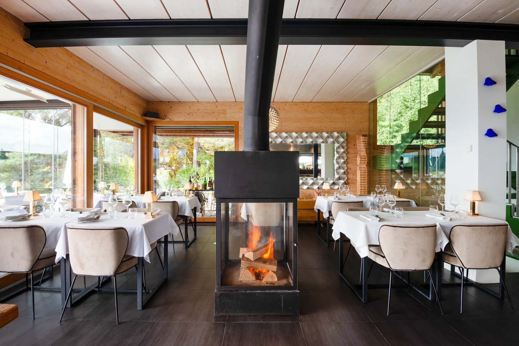 The dining room at Saskia's, tables laid around the central fireplace