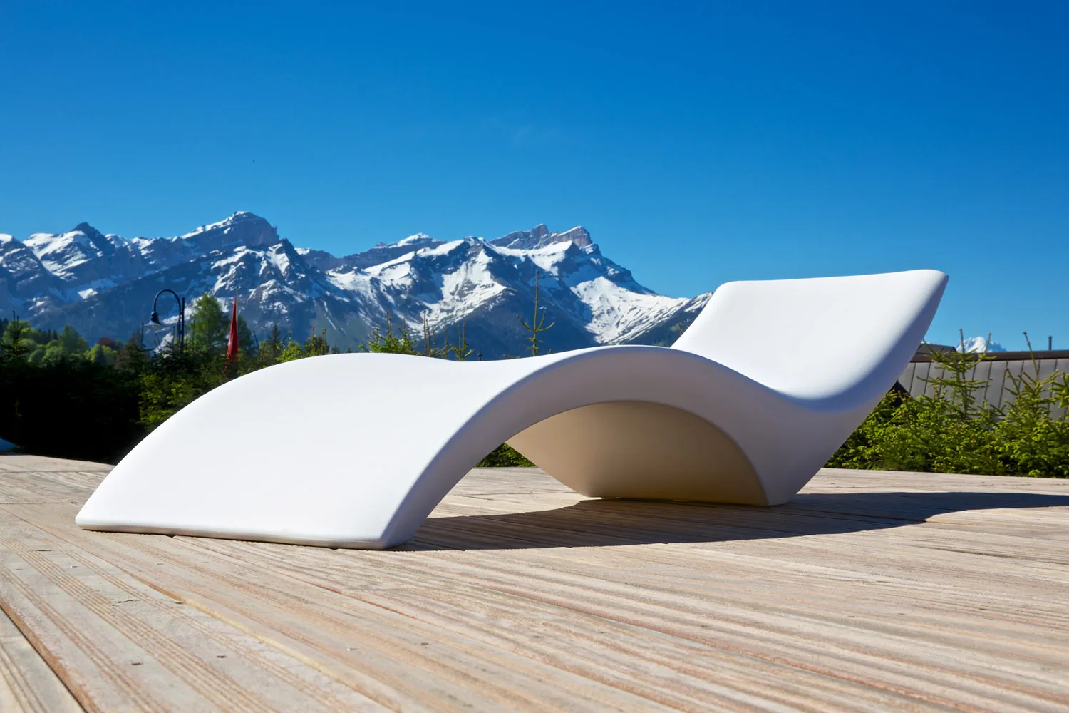 A lounger on the spa deck, the Alps beyond